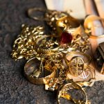 Old and broken jewelry  and on Euro banknotes on dark background. Sell gold for money  concept.